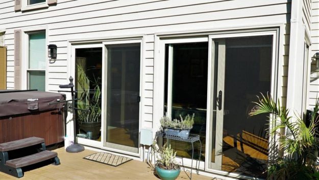 Two white sliding doors are on a house.
