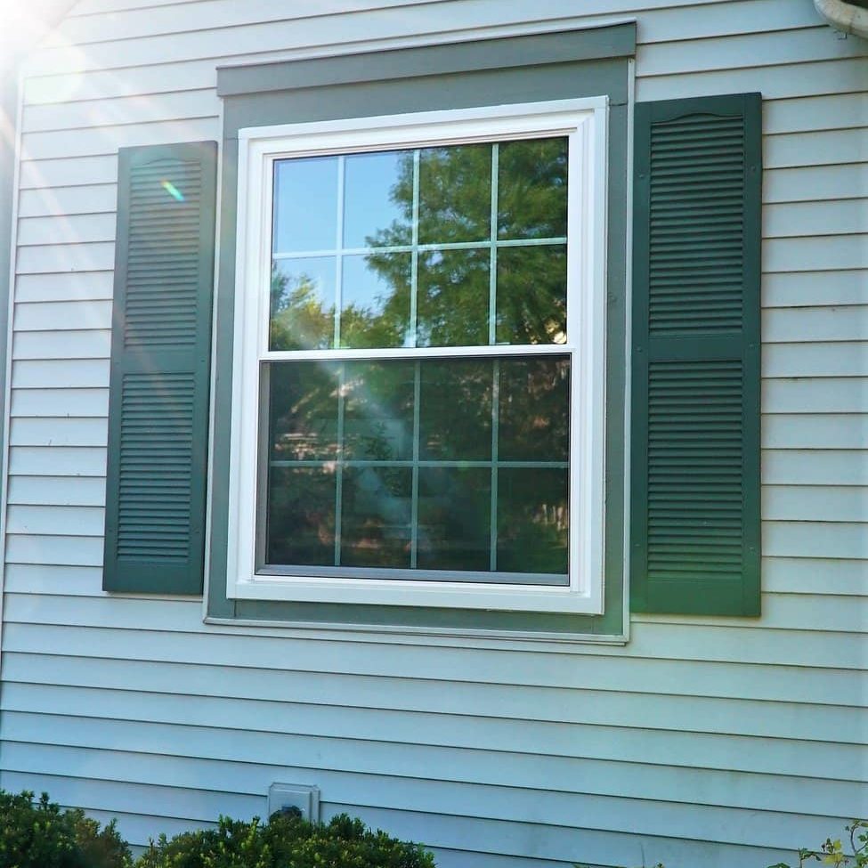 A single window has green shutters.