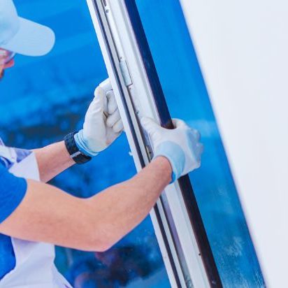 A man holding an old or new window to remove or install it.