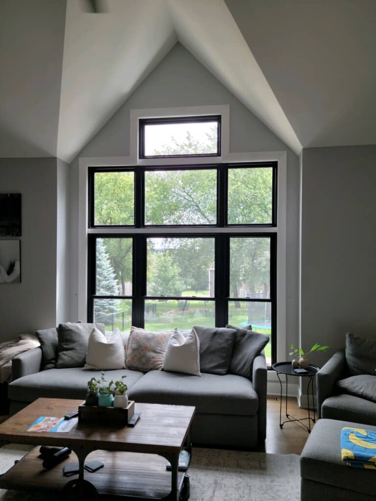 A large window with a complex frame brightens a living room.