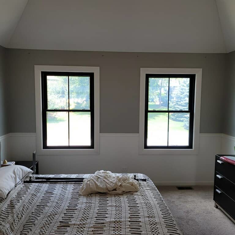 Two black windows in a bedroom.
