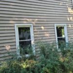Two double hung windows installed on the side of a home