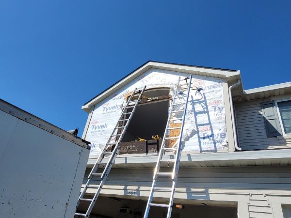 A house undergoes renovations for siding and windows.