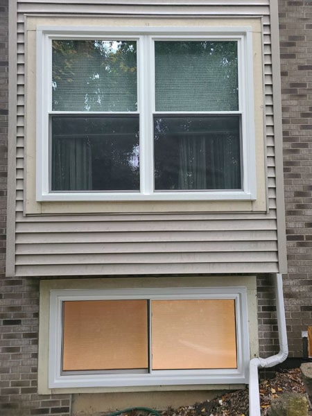 This egress window is parallel to the pair of double hung windows above it.