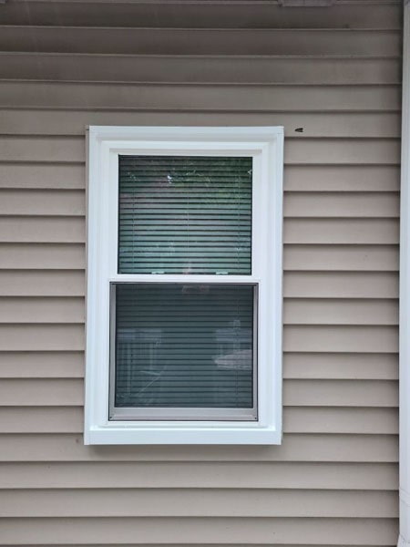 A double hung window with shades down.