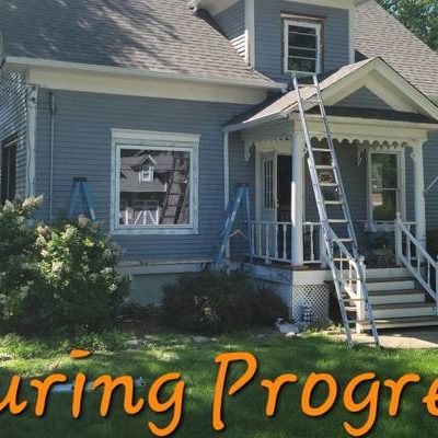 A ladder rests against an old house.
