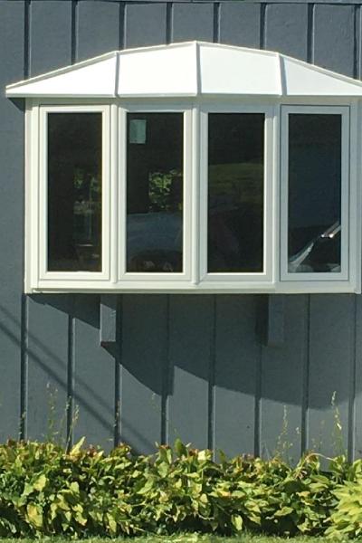A white bow window contrasts against a home's facade in Lake in the Hills, IL