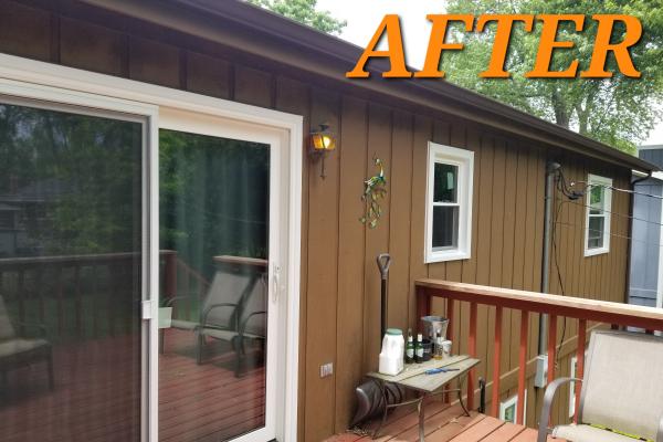 A sliding patio door with a white frame accompanies a new deck