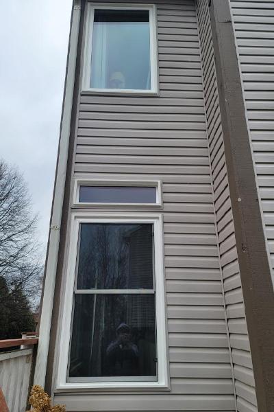 Three windows on a tan house