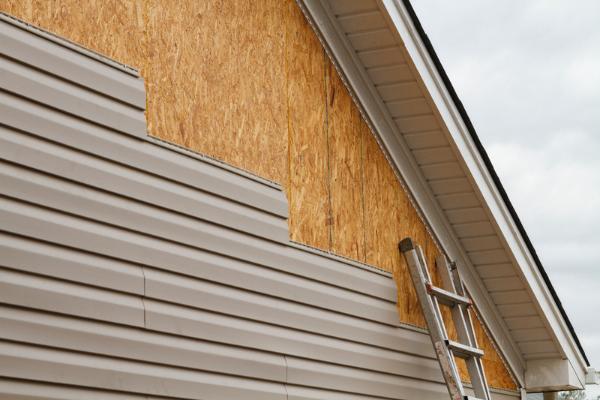 Siding contractors completing installation on a home