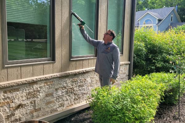 Travis Williams caulking a window during a window replacement project