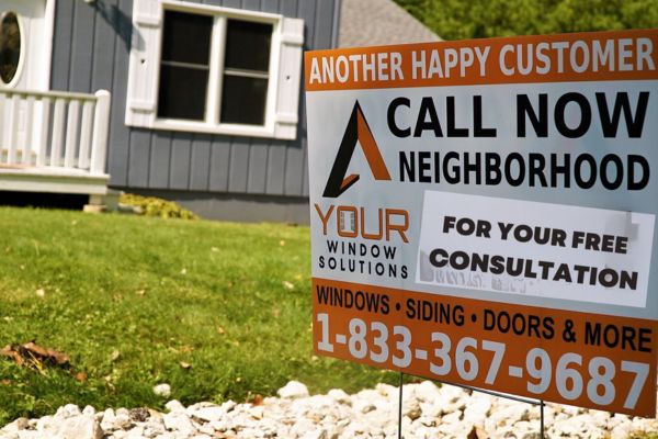 Your Window Solutions sign in front of a finished exterior home improvement project