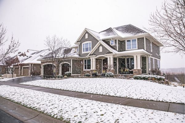 A snow-covered home with new siding and windows