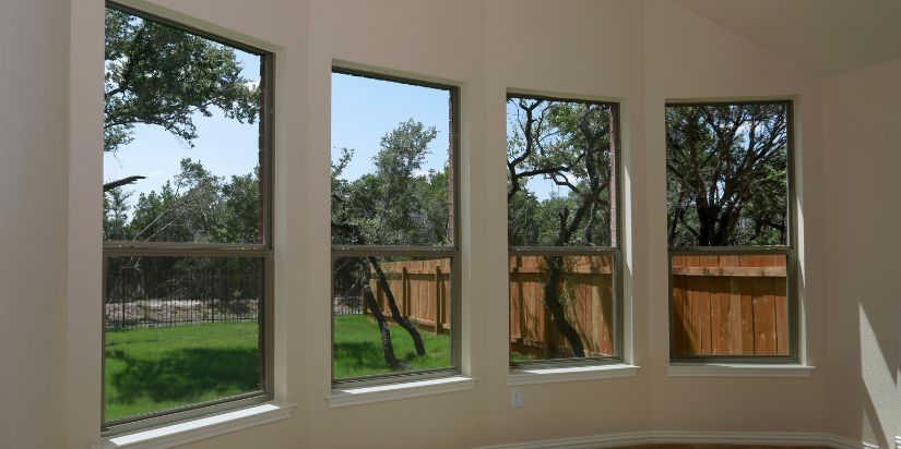 A row of new windows looking out at a backyard