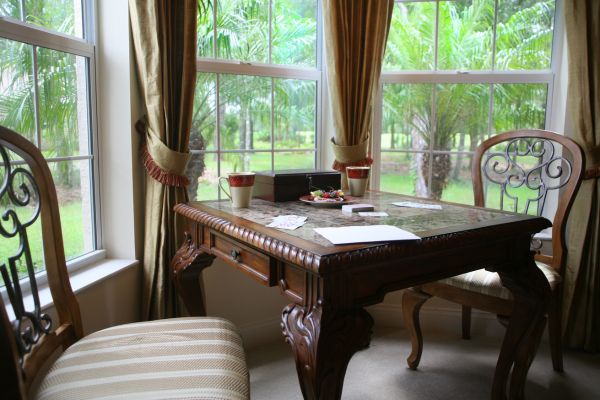 A table and chairs inside the interior space of a bay window