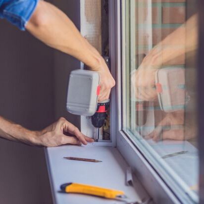 Someone using a drill to install a new window