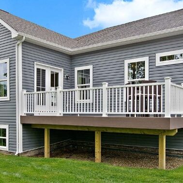 Back Exterior Of House The exterior of the back of a house with blue siding and a wooden deck.