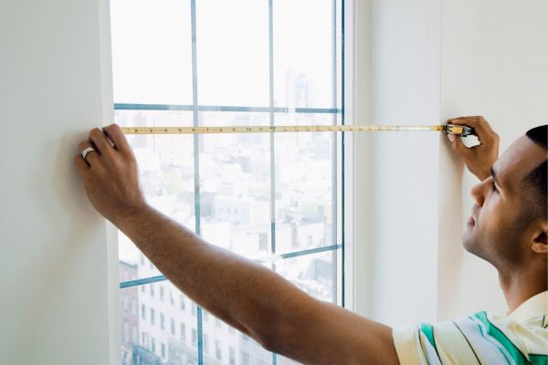 Someone measuring window for egress window installation